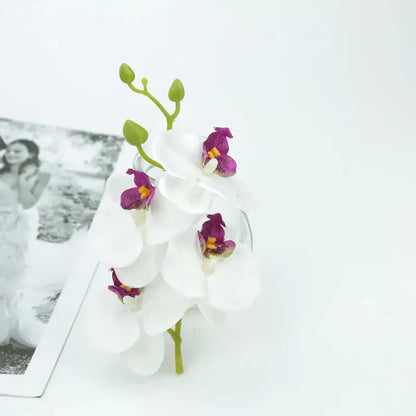 A delicate vibrant silk butterfly orchid bouquet with white petals and purple centers for wedding and home decor
