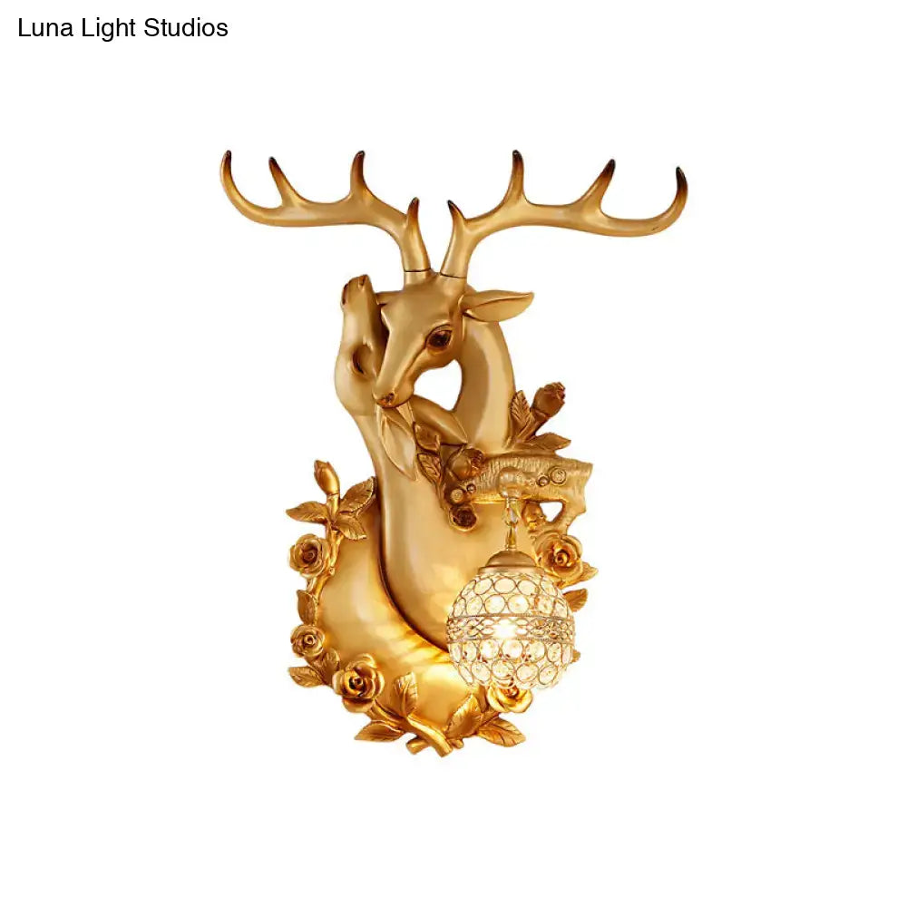 Golden deer head accent wall sconce with ornate antlers, rose embellishments, and crystal globe bedroom light