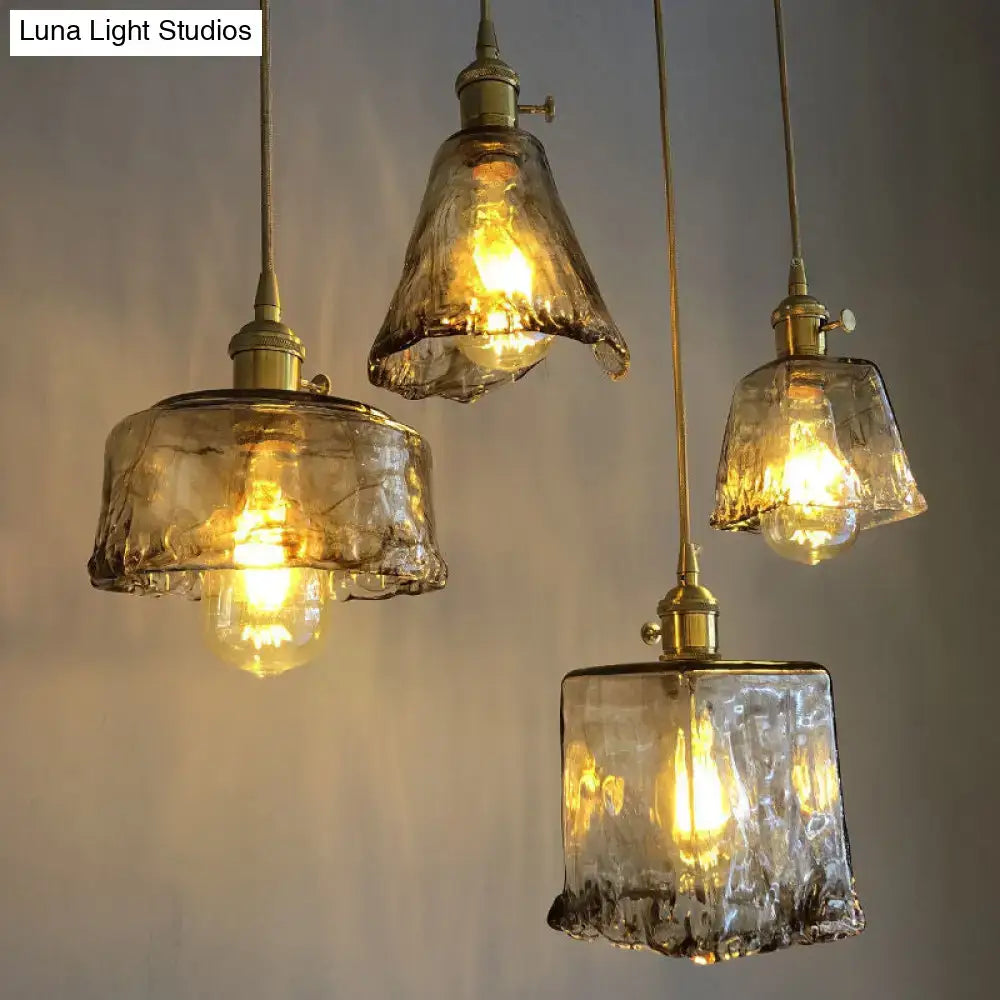 Four hand-blown amber alabaster glass pendant lamps with brass fixtures and exposed filament bulbs for living room lighting