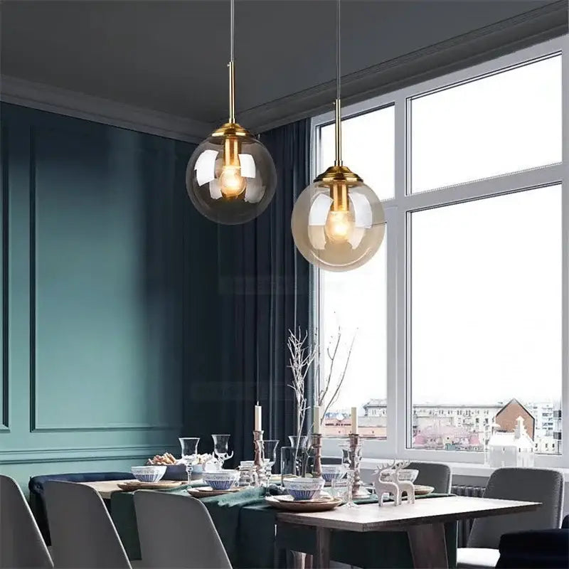 Two modern pendant lights with gold-finished metal and vintage amber decorbites gray glass ball shades for bedroom decor