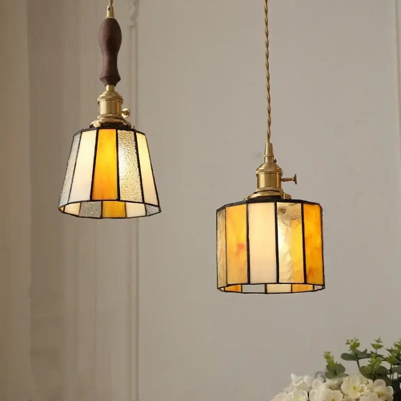 Two vintage amber and cream stained glass pendant lamps with brass fixtures and decorbites copper knob switch