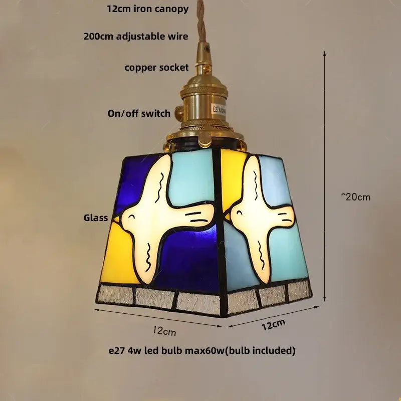 Vintage amber and cream stained glass pendant lamp with knob switch featuring stylized white birds and decorbites copper knob