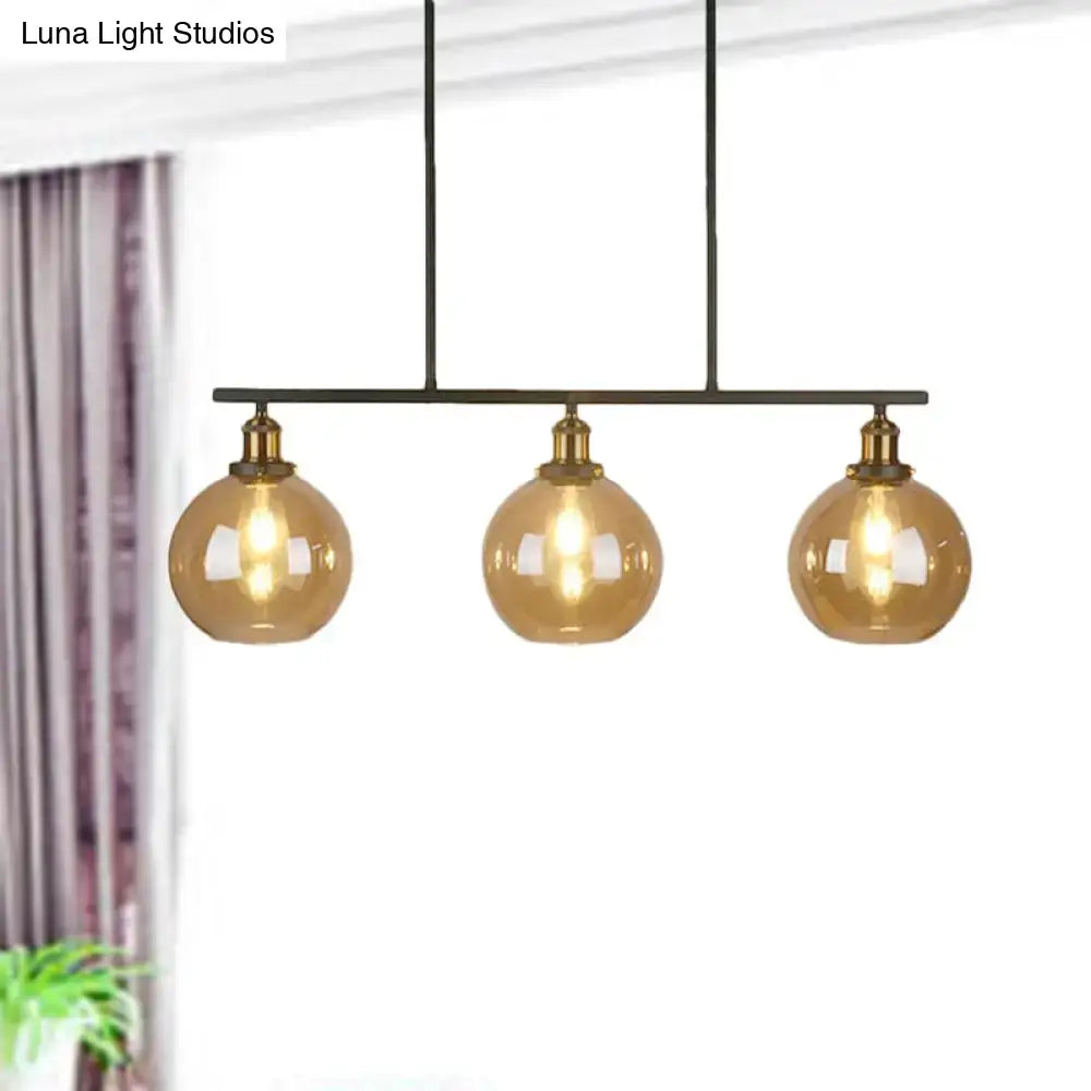 Modern three-light pendant fixture with amber glass globes and brass accents for 220v-240v lighting use