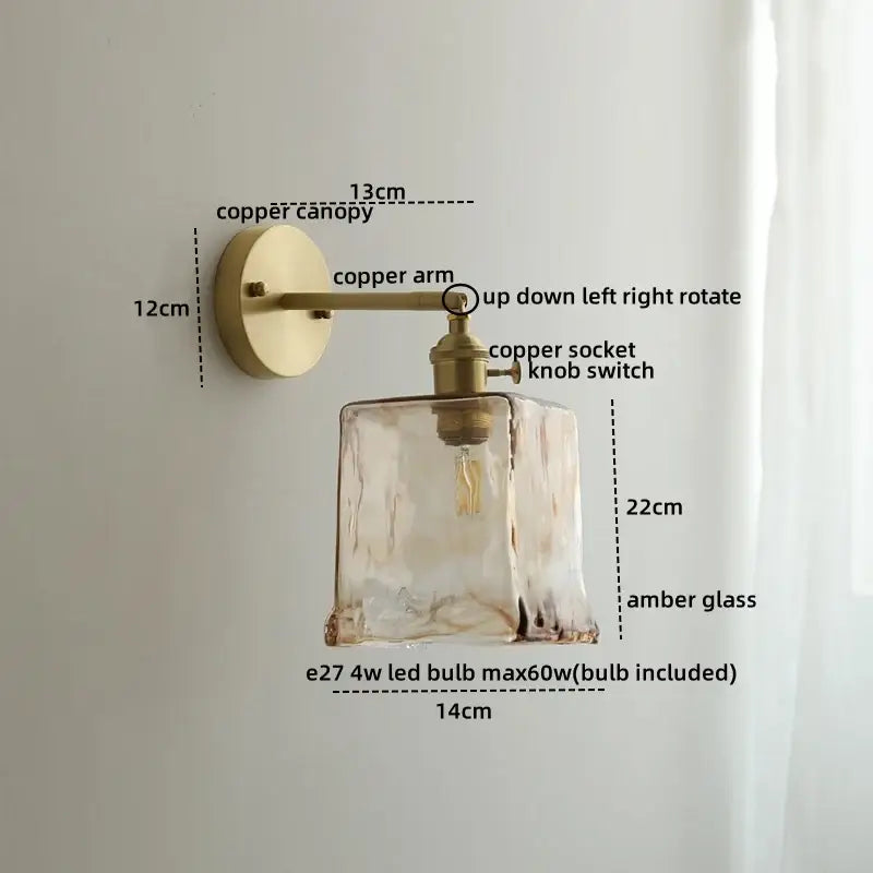 A warm amber glass copper LED wall lamp with textured faceted design and brass hardware for bedroom use
