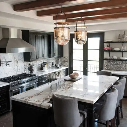 Vintage amber glass pendant light with brass accent above kitchen island with white marble countertop