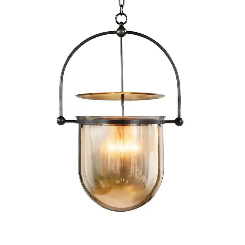 Vintage amber glass pendant light featuring a warm amber glass pendant with black metal frame and brass accent for dining room