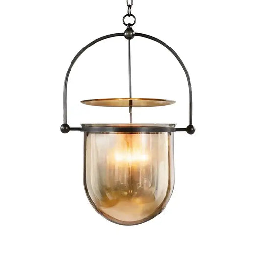 Vintage amber glass pendant light featuring a warm amber glass pendant with black metal frame and brass accent for dining room