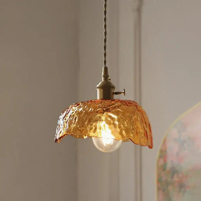 Vintage amber glass pendant light with textured amber glass, brass fixture, and twisted cord for kitchen island lighting
