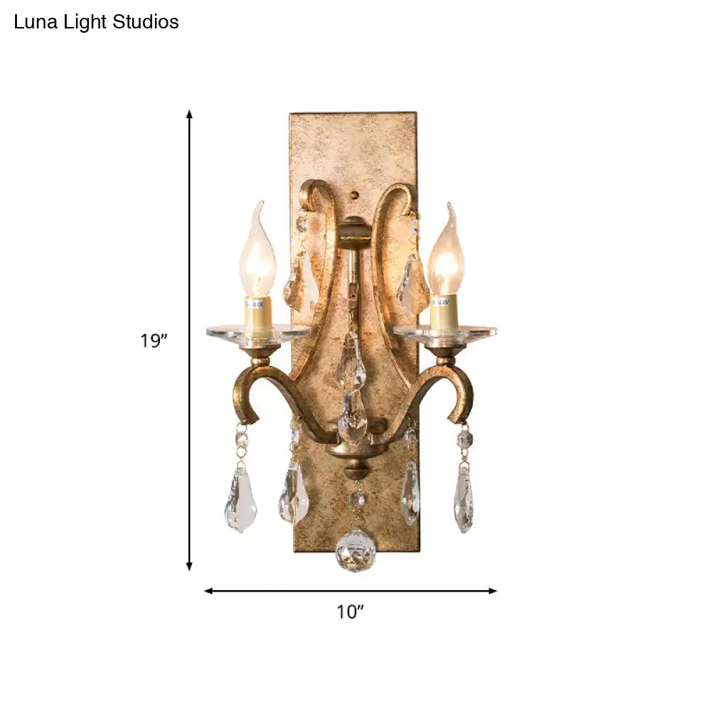 Antique gold-finished wall lamp sconce with two candle-style bulbs and dark purple clear crystal teardrop pendants