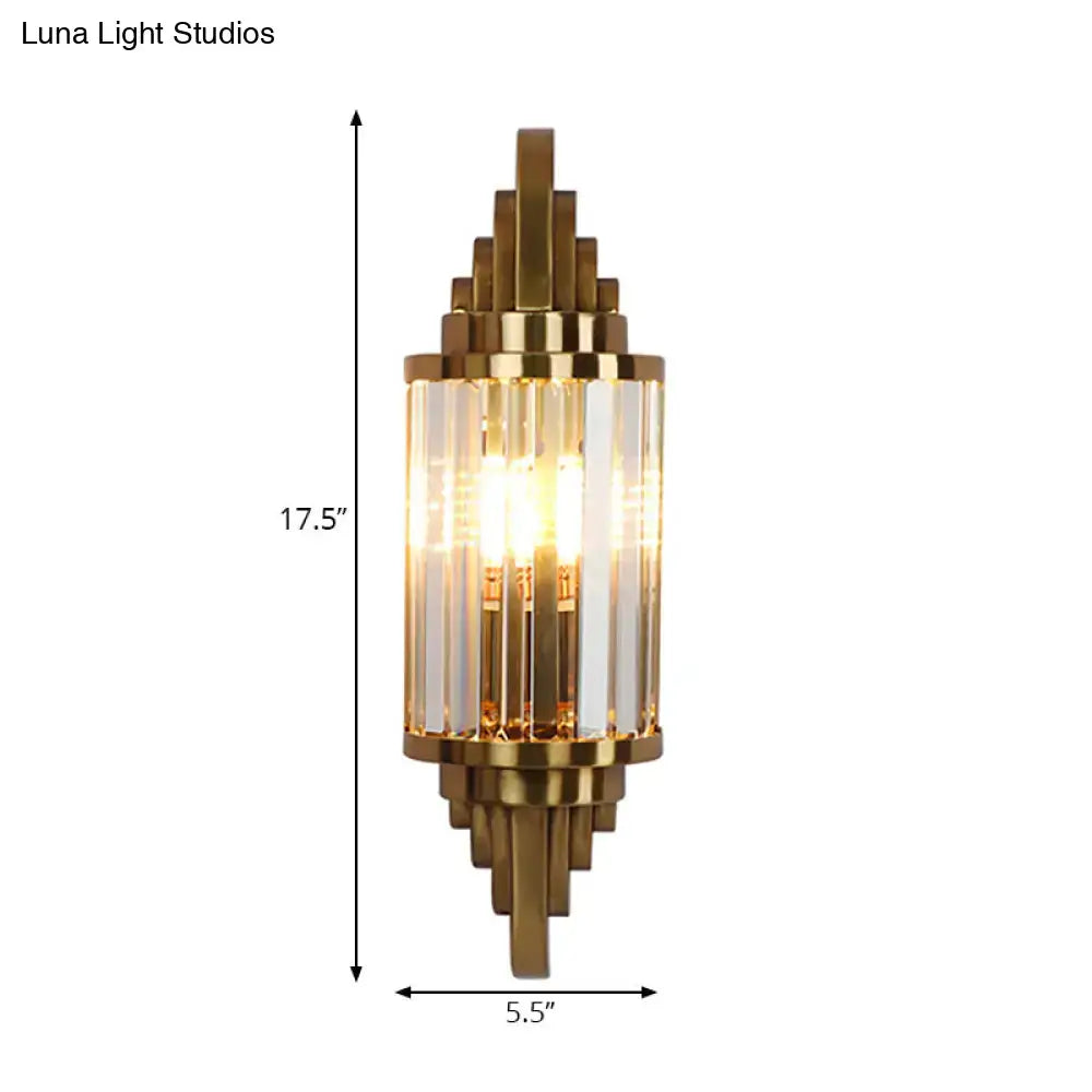 Gold-toned art deco wall sconce with clear crystal prism vertical rods and geometric metal frame for living room use
