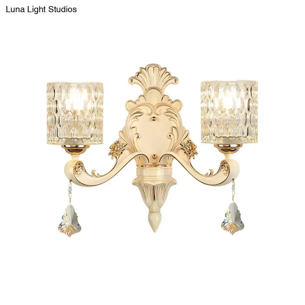 Elegant cream-colored vintage glass wall light with ornate design, crystal-cut glass shades, and faceted crystal pendants