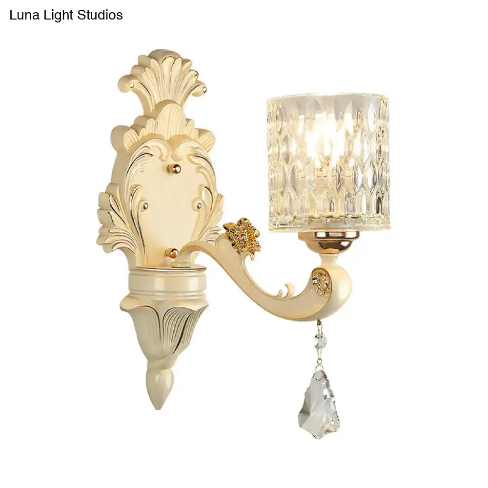 Cream-colored ornate vintage beige and gold glass wall light with faceted crystal shade and teardrop crystal pendant