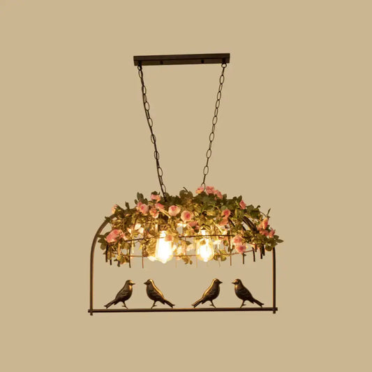 Vintage bird cage iron hanging light with black metal frame pink roses greenery and three exposed bulbs with bird figurines