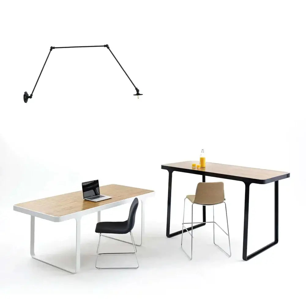 Vintage black adjustable loft wall light with articulated lamp mounted above modern minimalist desk with light wood top
