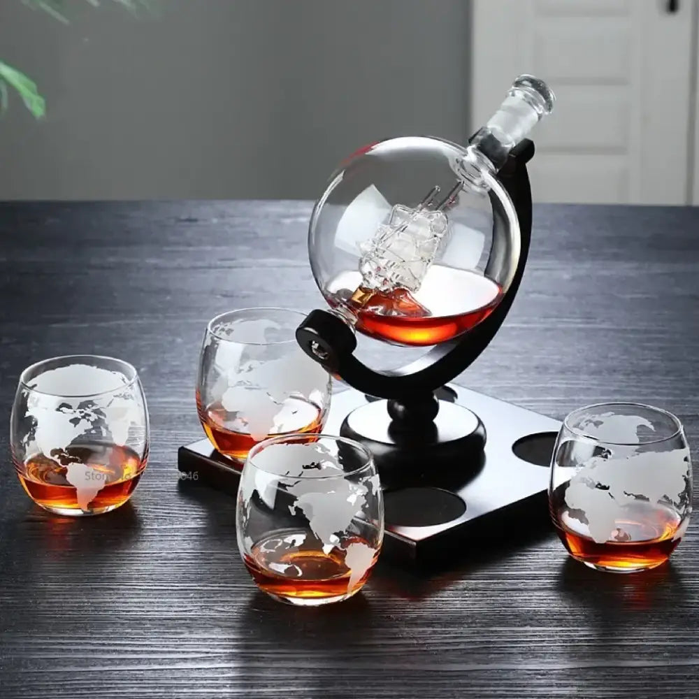 Vintage black earth decanter set featuring a clear glass globe decanter with etched world map and black metal stand filled with amber liquid