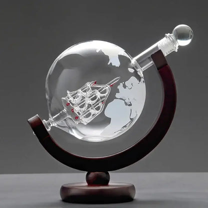 Vintage black earth decanter set featuring a clear glass globe with etched world map and miniature ship on wood stand