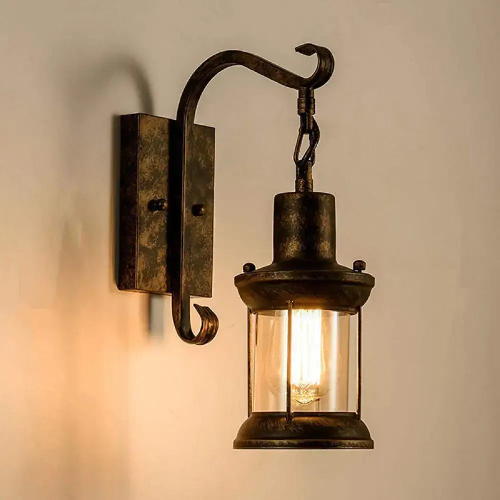 Antique bronze-finished wrought iron lantern wall light fixture with clear glass and visible filament bulb for dining room