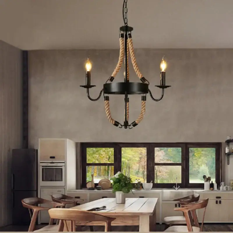 Vintage black metal chandelier with industrial hemp rope accents and three lit candle bulbs for dining room decorbites decor