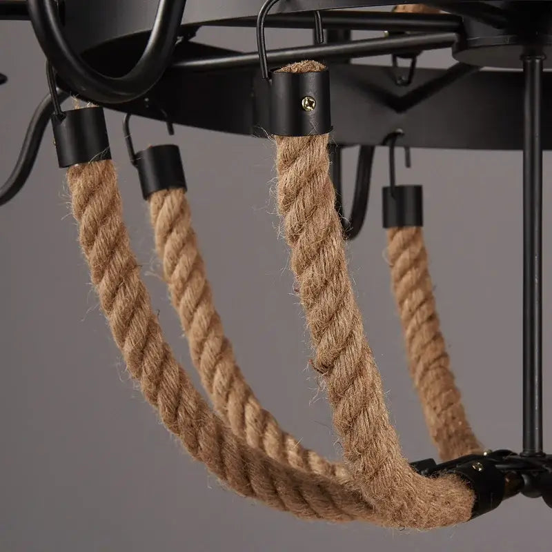 Thick natural brown hemp rope hangs from vintage black metal hooks in industrial hemp rope chandelier decorbites design