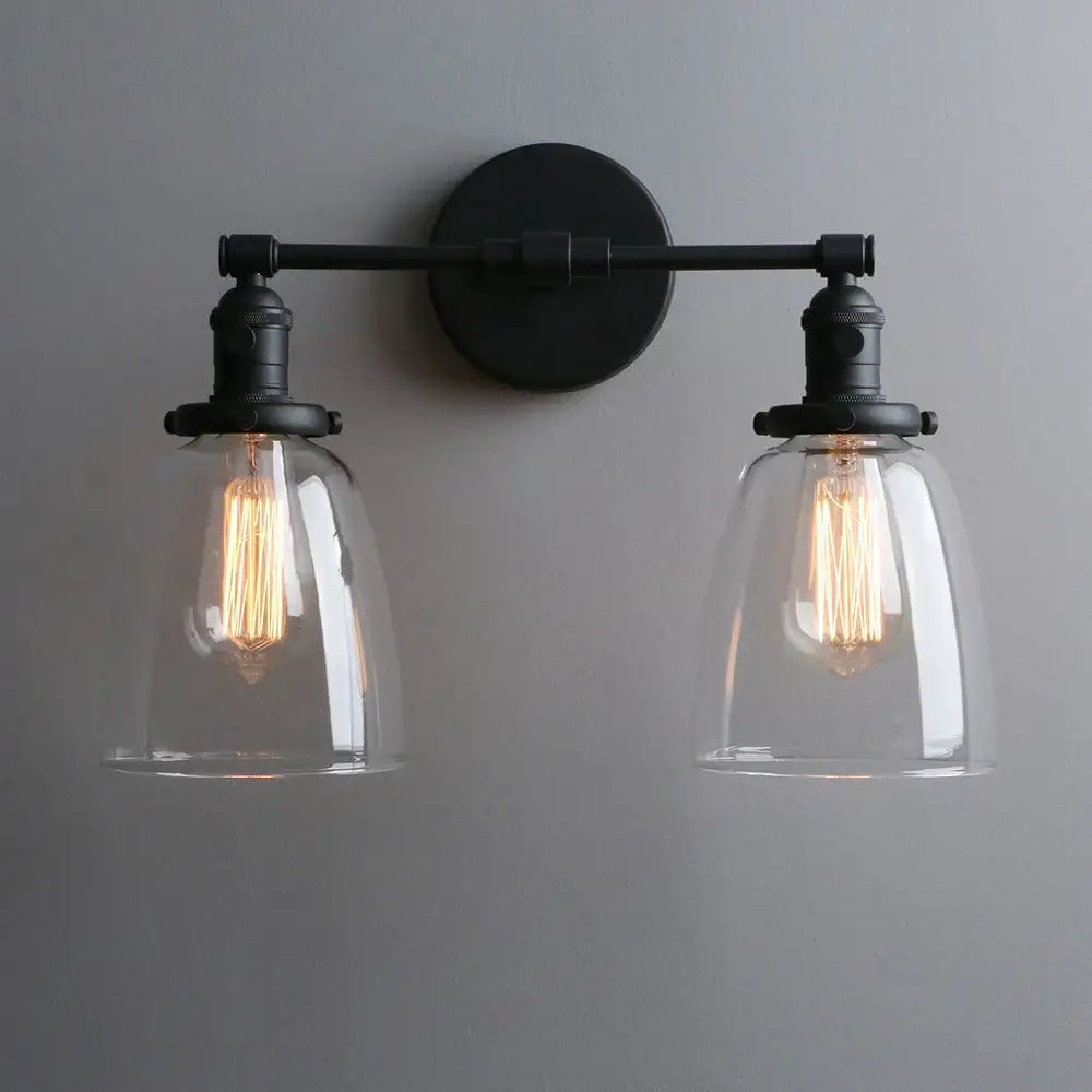 Vintage black wall sconce with two clear glass shades and exposed filament bulbs for bedroom lighting