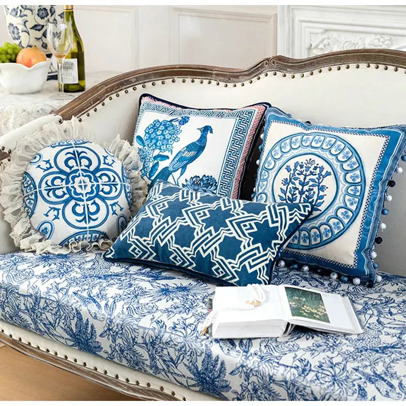 Vintage blue and cream peacock toile pillow cover with intricate lace trim and pom-pom accents for living room cushion
