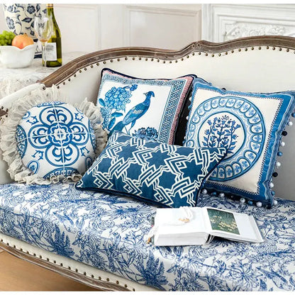 Vintage blue and cream peacock toile pillow cover with intricate lace trim and pom-pom accents for living room cushion