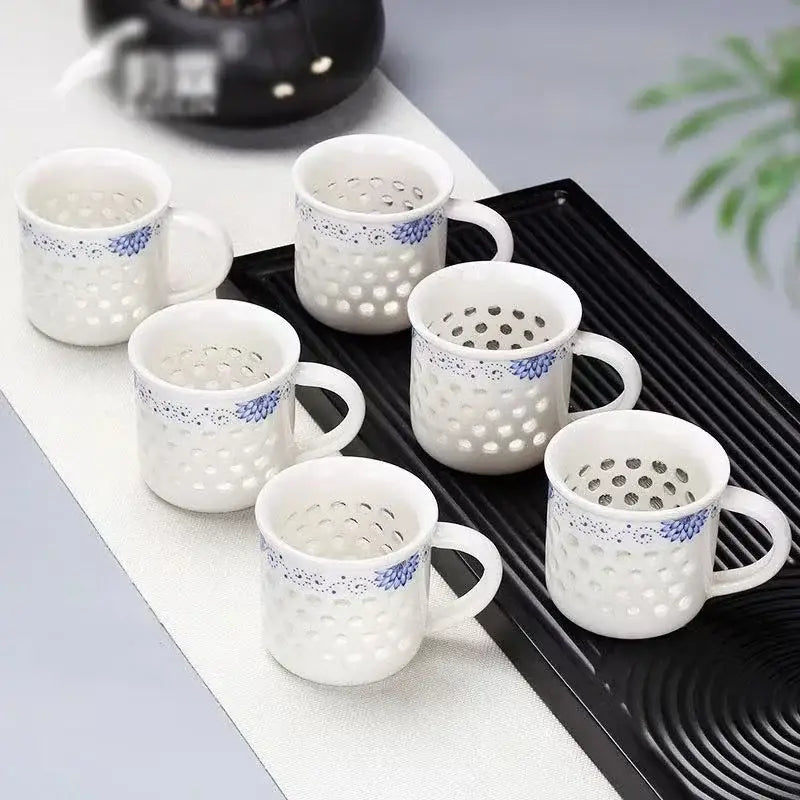 White ceramic tea cup set with blue floral patterns and perforated sides perfect for vintage dining room use