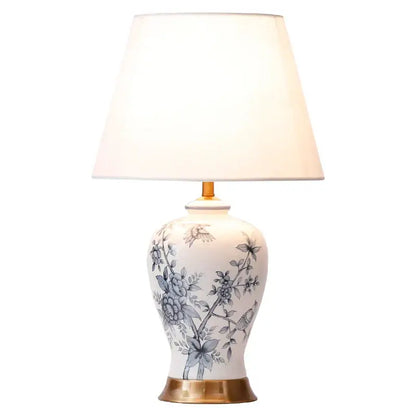 White porcelain table lamp with blue floral and bird motifs and gold-toned base decorbites blue white decor