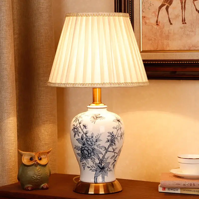 White porcelain table lamp with blue floral hand-painted design and gold-toned base by decorbites blue white
