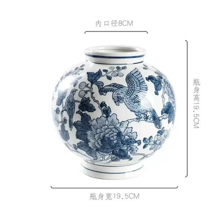 A round white porcelain vase with intricate blue white hand-painted birds and floral decor for living room use