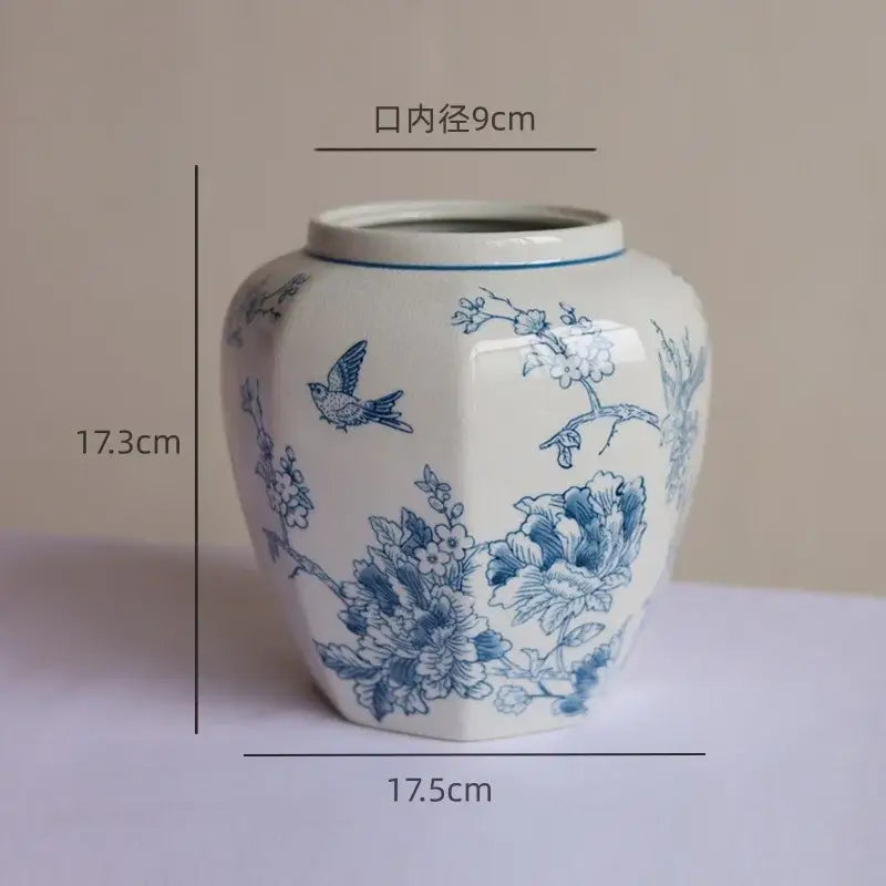 A white blue white porcelain vase with hexagonal body and hand-painted floral and bird decorbites blue white motifs