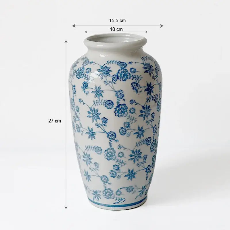 A tall porcelain vase with intricate blue floral patterns and a glossy finish for living room decorbites blue white decor