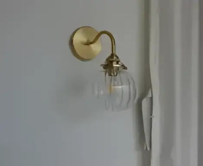 Vintage brass led wall lamp with gold-toned ornate metal detailing and clear glass globe for bedroom sconce lighting