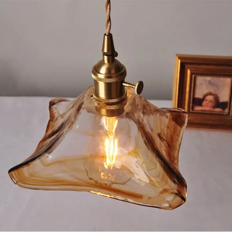 Vintage brass and amber glass pendant light featuring a warm amber glass pendant with brass socket and twisted cord decorbites amber glass