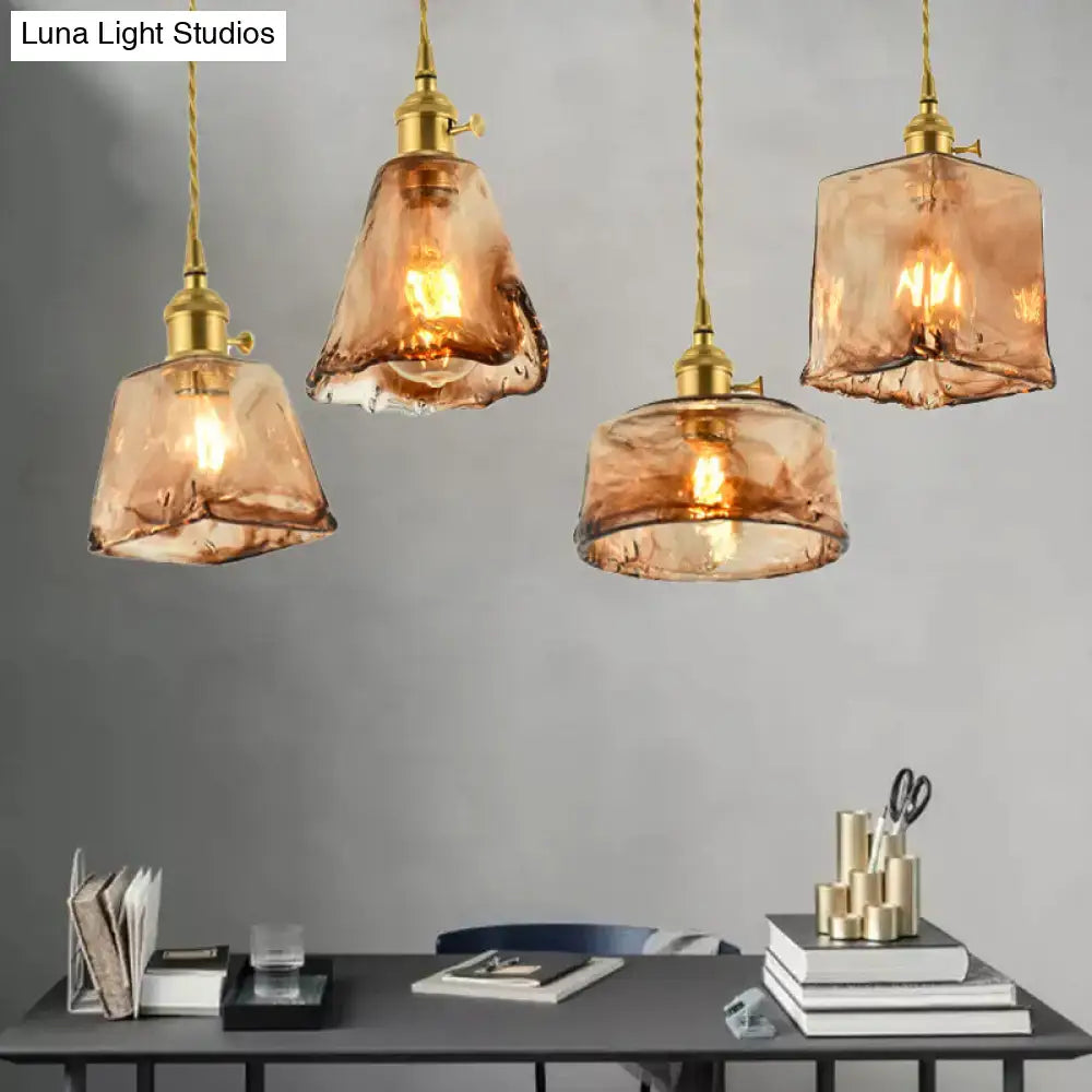 Four amber tan glass brass shaded drop pendant lights with handmade vintage design hanging above desk