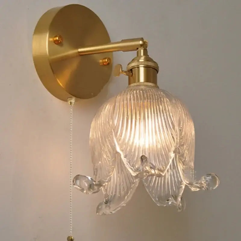 Gold-toned vintage brass wall light with clear ribbed loft amber glass shade shaped like an open flower for bedroom decorbites loft amber