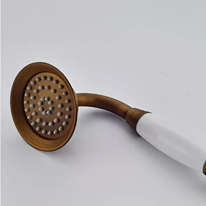 Antique brass hand shower head faucet set with white ceramic handle and circular spray face for bathroom use