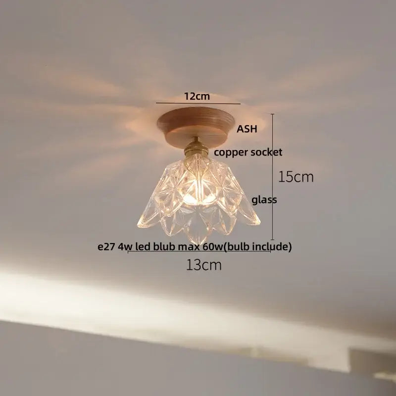 Vintage brass and clear glass LED ceiling light with a clear glass pendant, copper socket, and wooden base for bedroom decorbites