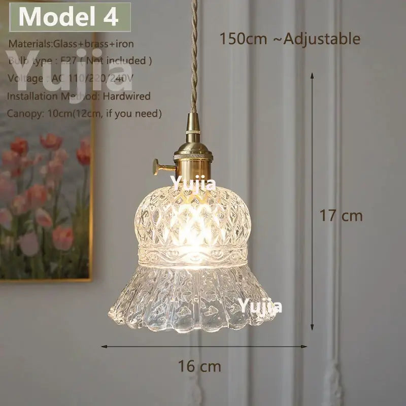 Vintage brass pendant light with clear glass floral shade and polished copper finish on adjustable braided cord