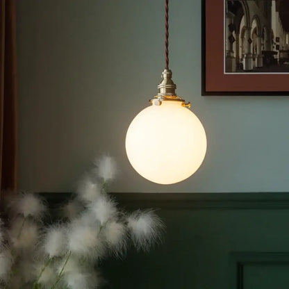 Vintage brass and decorbites cream glass ball pendant light with warm glowing spherical glass for kitchen decor