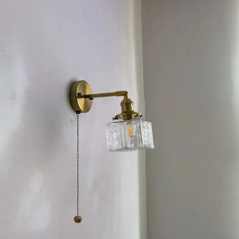Vintage brass and glass led wall lamp with clear textured cube shade and pull chain for bedroom lighting