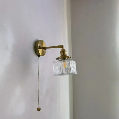 Vintage brass and glass led wall lamp with clear textured cube shade and pull chain for bedroom lighting