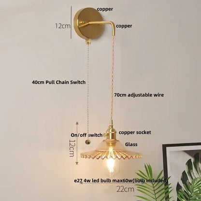 Vintage brass wall lamp with gold-toned copper body and green glass led frilled shade with adjustable wire
