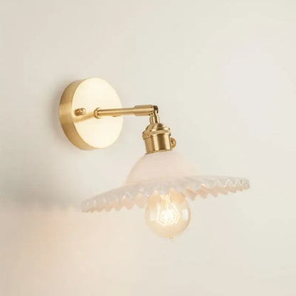 Vintage brass wall light with frosted scalloped glass led shade and exposed bulb for bedroom use
