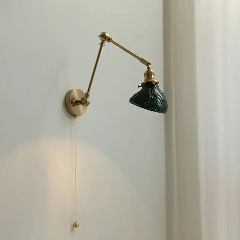 Vintage brass wall light fixture with dark green ribbed glass shade and adjustable arm for bedroom use