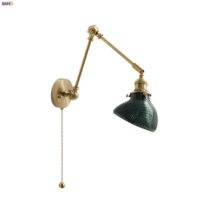 Vintage brass wall light fixture with dark green ribbed glass shade and adjustable arm for bedroom use