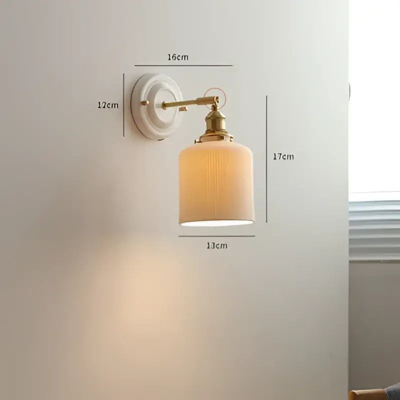 Vintage brass led wall light with ribbed off-white glass shade designed as a bedroom sconce fixture