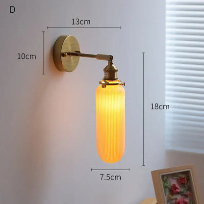 Vintage brass and amber ribbed glass led wall light featuring a warm glow for bedroom sconce lighting