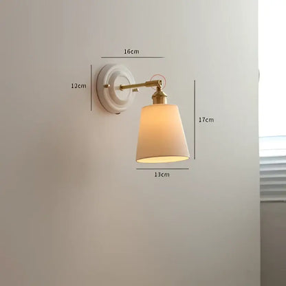 Vintage brass led wall light with ribbed glass and beige fabric shade diffusing warm light for bedroom sconce