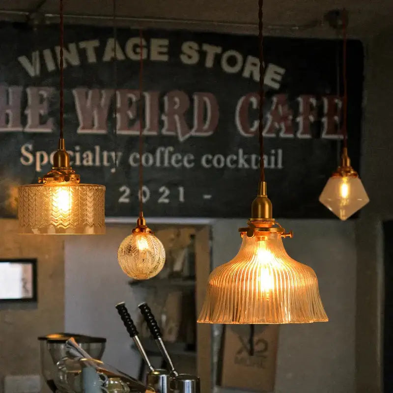 Three vintage brass and textured glass led pendant lamps with brass fixtures hanging in a dining room setting